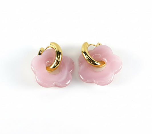 Pair of pink flower-shaped earrings with gold loops on a bright white background